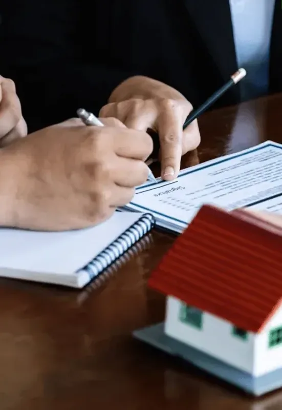 Signing a contract beside a model house